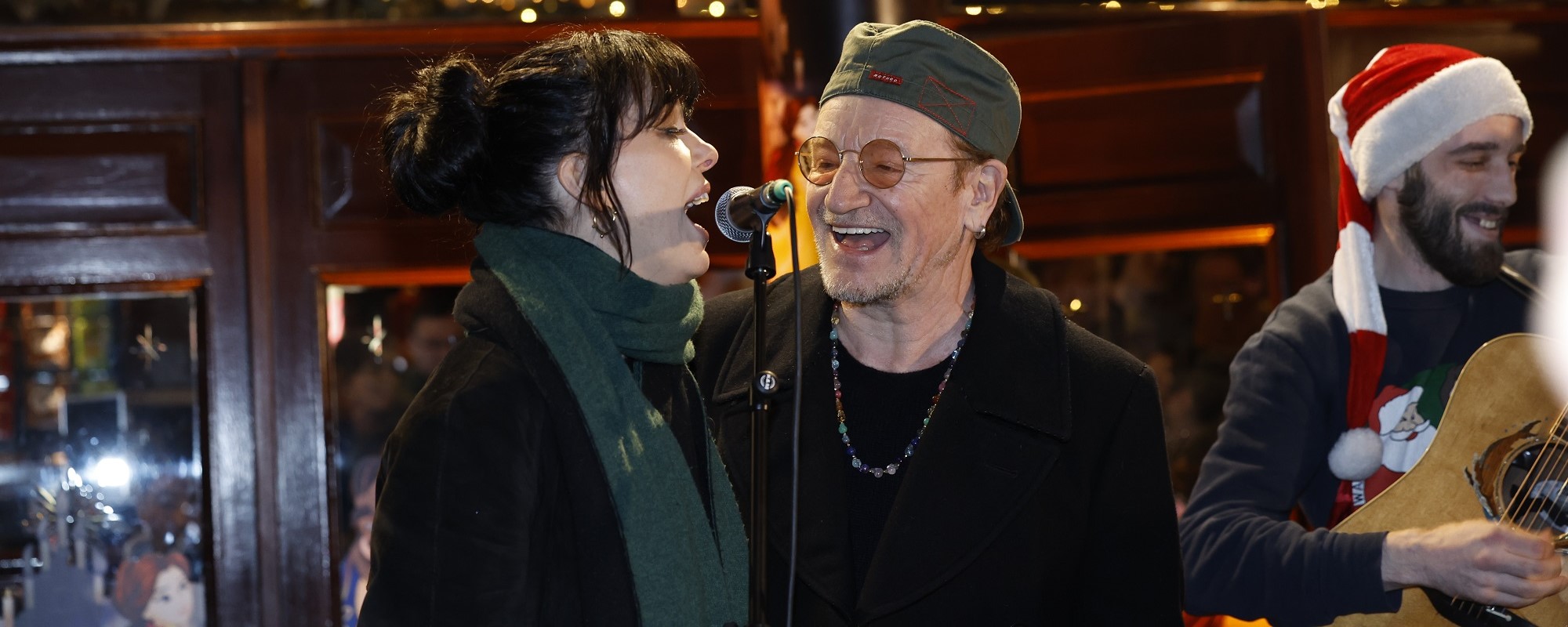 Regardez Bono Sing Rocking Classic Holiday Tune de U2 avec Imelda May lors de l'événement caritatif annuel de Noël dans la rue à Dublin